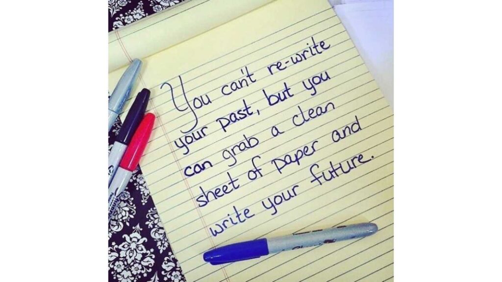 image of Stephanie's handwriting on a legal pad that says "You can't re-write your past, but you can grab a clean sheet of paper and write your future." A few sharpie markers are laying around the paper.